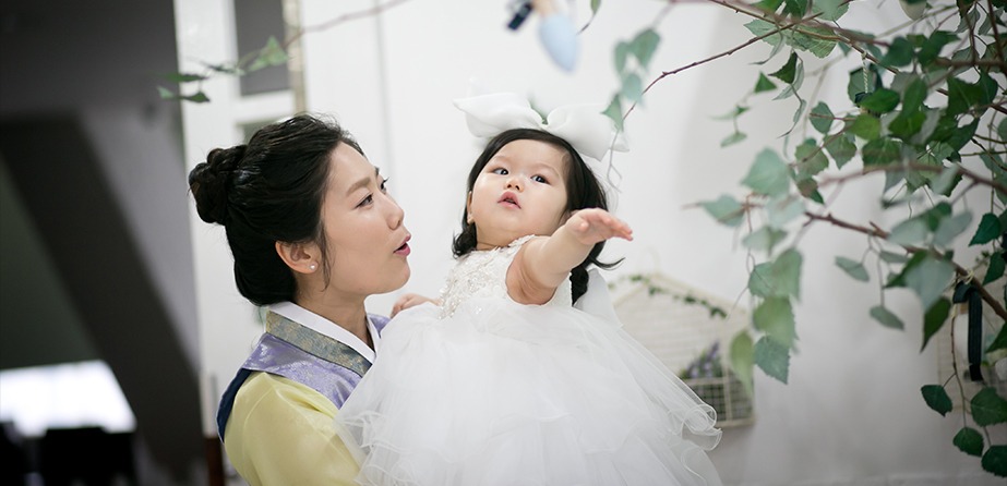 서윤이를 안은 엄마, 나뭇가지 배경 앞에서 아이가 손을 뻗는 순간