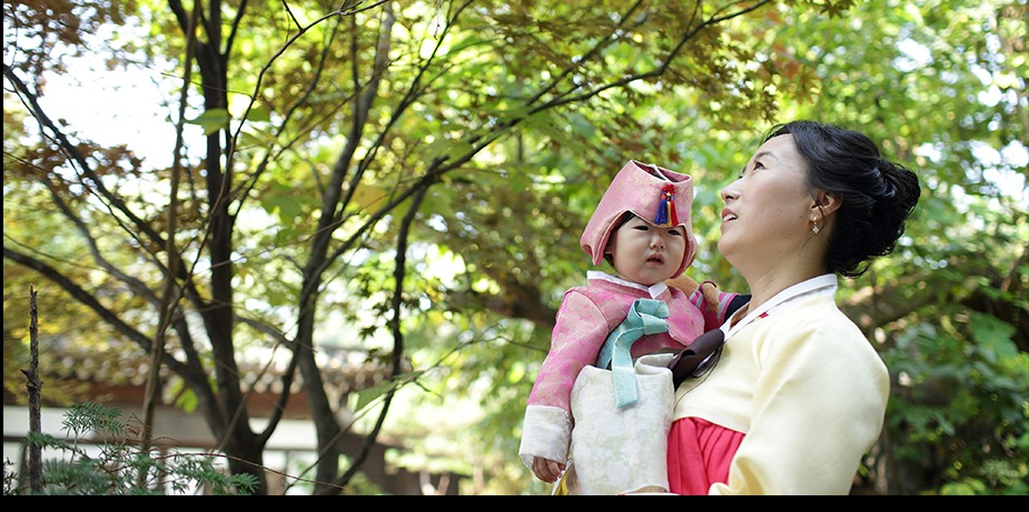 엄마 한복 차림으로 나무 아래 시원이를 안은 모습