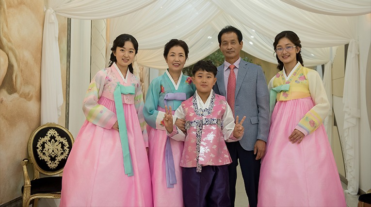돌잔치홀 천막 아래 — 가족 5인, 아들 돌복 차림
